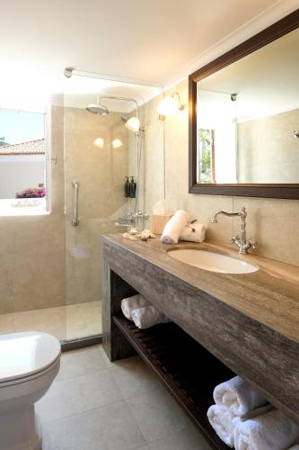 a bathroom with a sink and a shower and a toilet at Nissia Traditional Residences Spetses in Spetses