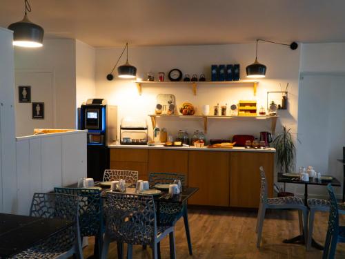 a restaurant with tables and chairs and a kitchen at Hôtel Saint-Florent, à 2 pas du Théatre Antique d'Orange in Orange