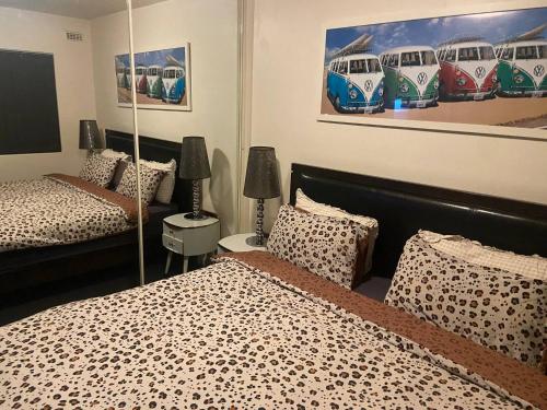 a bedroom with two beds and two paintings on the wall at Scarborough Beach Shack in Perth