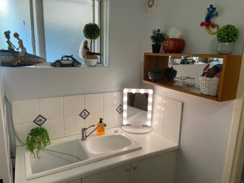 a bathroom with a sink and a mirror at Scarborough Beach Shack in Perth