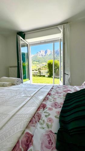 a bedroom with a large bed with a large window at Villa Amore in Oltre il Colle
