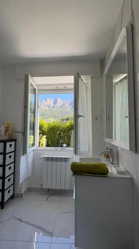 a bathroom with a window with a view of a mountain at Villa Amore in Oltre il Colle