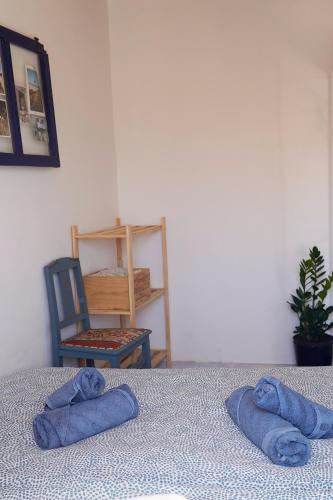 two towels on a bed in a room with a chair at Toca da raposa in Raposeira