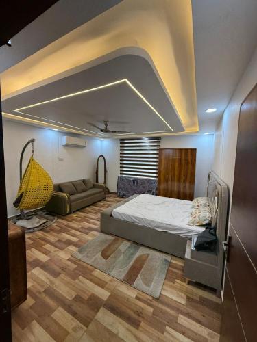 a bedroom with a bed and a couch in it at Oliv Faram house in Greater Noida