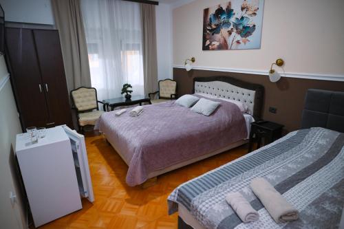 a bedroom with two beds and a mirror in it at Bed&Breakfast INTERMEZZO CAFFE in Kikinda