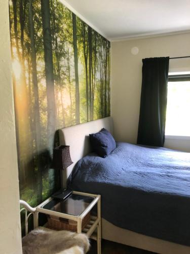 a bedroom with a bed and a window with trees at Bed and breakfast in Sauda