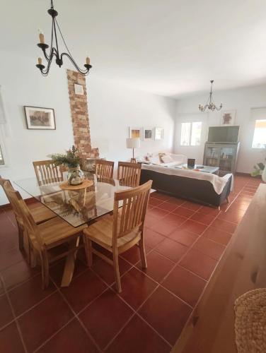 a living room with a table and chairs and a couch at Chalet Matalascañas in Matalascañas