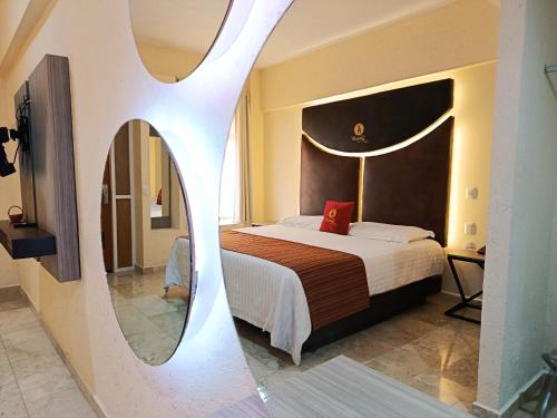 a bedroom with a large bed and a mirror at Hotel Yahalis in Jilotepec de Abasolo