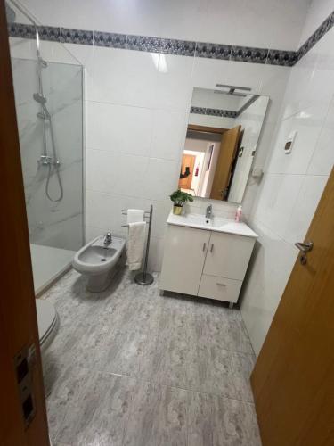 a bathroom with a toilet and a sink and a shower at Casa do Pateo in Évora