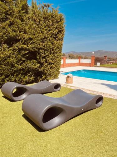 two pairs of scissors sitting on the grass near a pool at Villa Wanderlust Sitges Hills Exclusive pool only families in Olivella