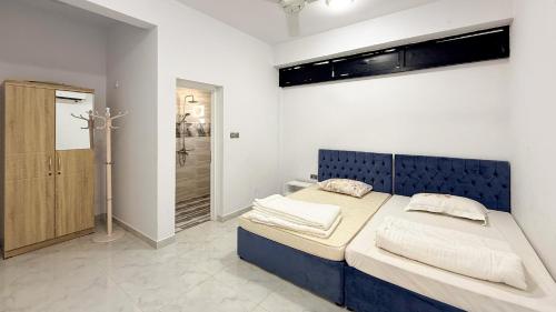 a bedroom with a blue bed and a walk in shower at Villa Berka in Barka