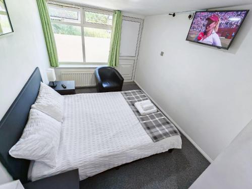 a small bedroom with a bed and a chair at Hawthorn Studio - Self Contained One-Bed Studio Flat in Oxford