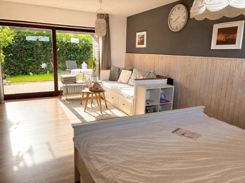 a bedroom with a bed and a clock on the wall at Gemütliche Heide-Ferienwohnung in Soltau