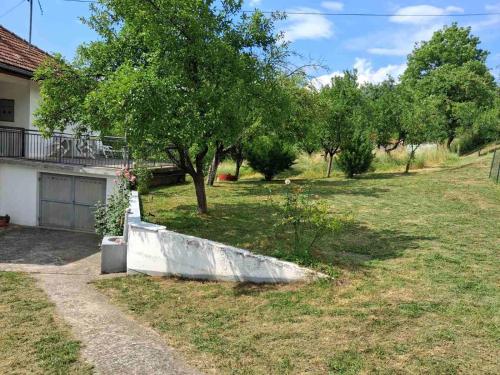 a yard with a tree and a house at Apartman Dream in Foča