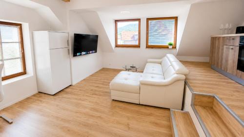 a living room with a white couch and a tv at Valora Central Apartment in Vrhnika