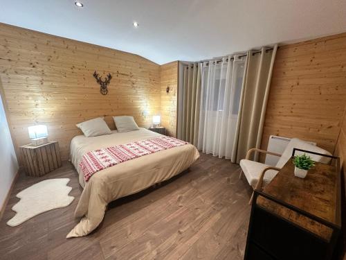 a bedroom with a large bed and a wooden wall at L'Appart'Chalet du Revermont in Cousance