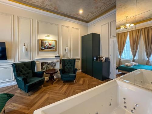 a bathroom with a tub and two chairs and a couch at Apartament z Jacuzzi Kraków ART Koletek in Krakow
