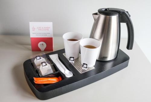 a tray with a coffee mug and a cup of coffee at Stay Hotel Guimarães Centro in Guimarães