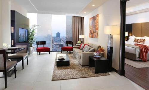 a hotel room with a bed and a living room at Sedra Al Alami Jeddah in Jeddah