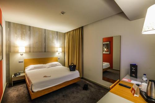ギマランイスにあるStay Hotel Guimarães Centroのベッドとバスルーム付きのホテルルームです。