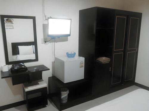 a bathroom with a sink and a mirror and a television at Mark Four Place Hotel in Phrae