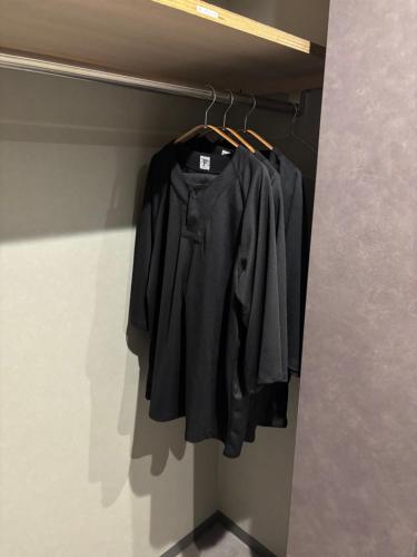 a black shirt hanging on a rack in a closet at B-sum M-1 in Matsuzaka