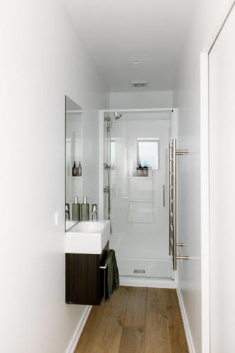 a white bathroom with a sink and a shower at The Albert Studio in Albert Town