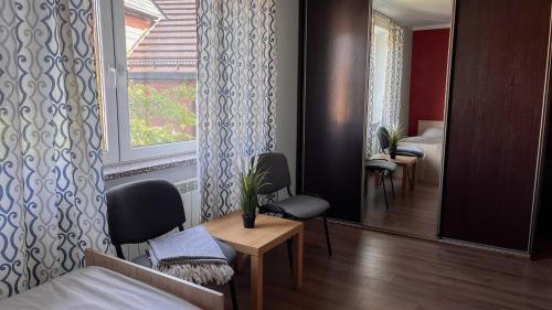 a room with a bed and chairs and a window at Apartament Ogrodowa in Muszyna