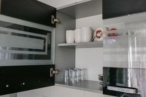 a kitchen with black cabinets and white appliances at Apartament Ogrodowa in Muszyna