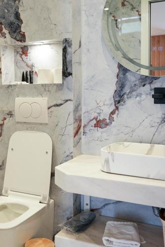 a bathroom with a white toilet and a sink at Blue Heaven Seaside in Borsh