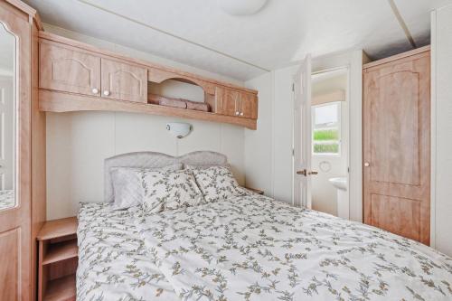 a bedroom with a bed and wooden cabinets at Vagunmaja in Haapsalu