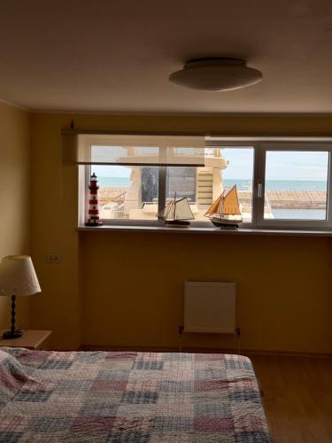 a bedroom with a large window with a view of the ocean at Двоповерхові апартаменти в яхт-клубі in Odesa
