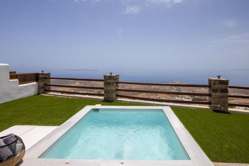 a swimming pool on a lawn with the ocean in the background at Felicia Exclusive Villa - Private Pool in Arnados