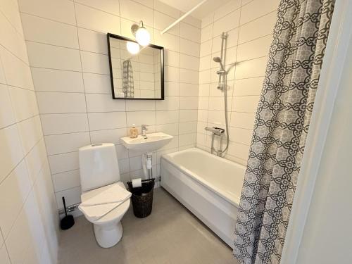 a bathroom with a toilet and a sink and a bath tub at Lysekil Apartment Hotel in Lysekil