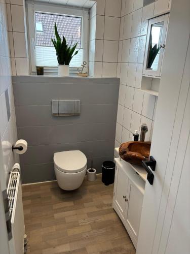 a small bathroom with a toilet and a window at Privatunterkunft Bingum in Leerort