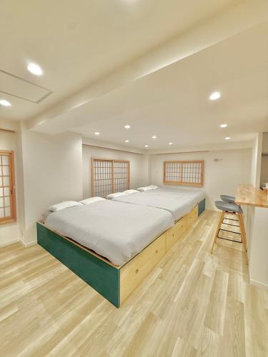 a bedroom with a large bed and a wooden floor at Central Roppongi House in Tokyo