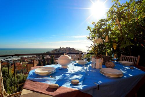 a table with a blue table cloth with a view of the ocean at casa vista mare con wifi, AC nelle 4 camere da letto e parcheggio privato in Imperia