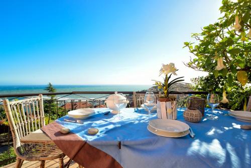 a table with plates and glasses on a blue table cloth at casa vista mare con wifi, AC nelle 4 camere da letto e parcheggio privato in Imperia