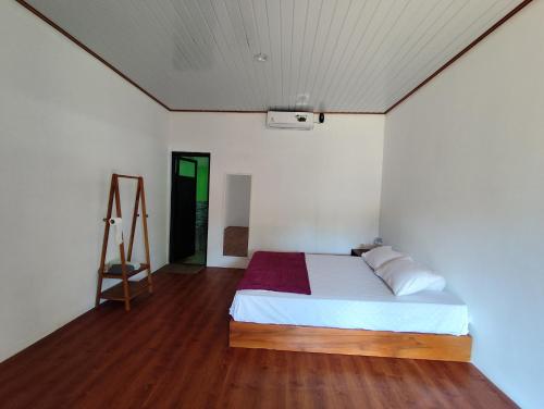 a bedroom with a bed and a wooden floor at Laendra Sunset Karimunjawa in Karimunjawa