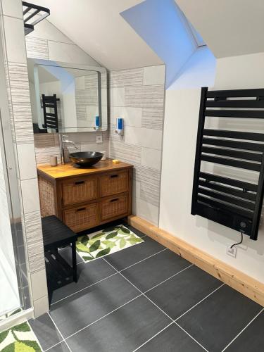 a bathroom with a sink and a mirror at L'Appart'Chalet du Revermont in Cousance