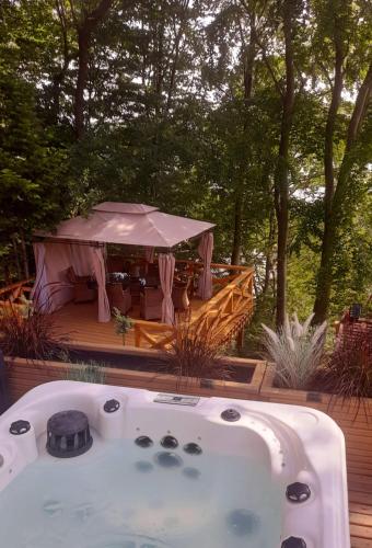 a jacuzzi tub on a deck with a tent at Mała Garda in Brodnica Dolna