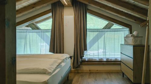 a bedroom with a bed and a large window at Tilio Chalet in Livigno