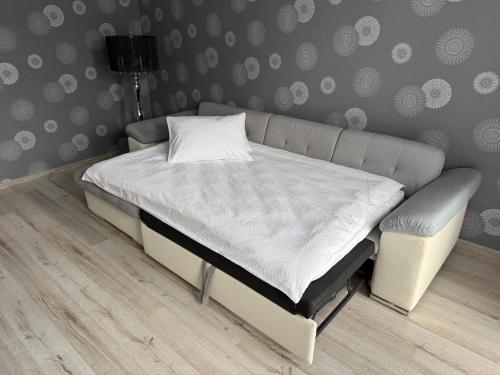 a bed in a bedroom with a gray wall at Lielais prospekts 54 in Ventspils