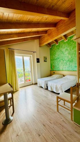 a large room with two beds and a large window at Agritur Due Valli in Livo