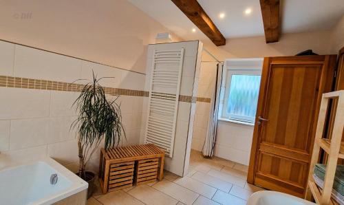 a bathroom with a white tub and a plant in it at Ferienhaus Flotte Biene Buggow nahe Usedom in Rubkow