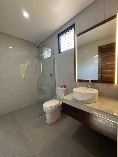 a bathroom with a toilet and a sink and a shower at Puri Bali Hotel in Lovina