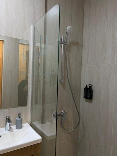 a shower with a glass door next to a sink at Luxoria hotel in Astana
