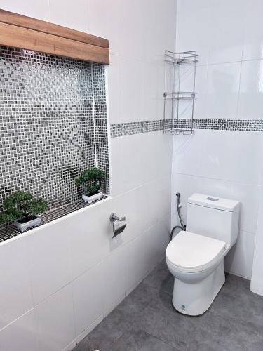 a white bathroom with a toilet and a window at Jungle Hideaway with Pool Wifi Smart TV in Ban Tai