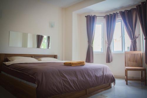 a bedroom with a bed with purple curtains and a mirror at Romruedee Resort in Sattahip