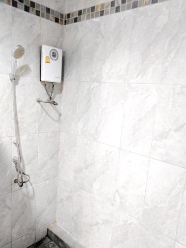 a bathroom with a shower with a hair dryer on the wall at Romruedee Resort in Sattahip